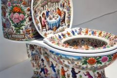 DALL·E-2025-09-02-20.59.55-A-photorealistic-close-up-of-a-white-porcelain-toilet-displayed-as-an-art-piece-its-entire-smooth-surface-painted-with-ornate-azulejos-style-designs