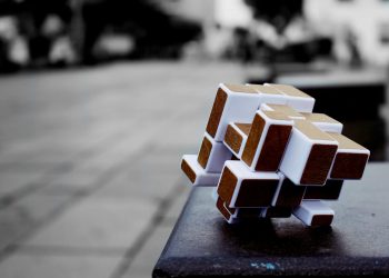 Artistic cube puzzle placed on a surface in an urban setting, capturing depth and focus.