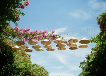 Conical hats strung between trees under a blue sky