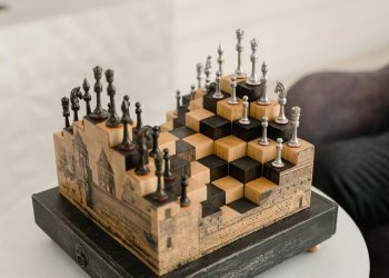 Artistic chess set with 3D pieces on an intricate wooden board indoors.