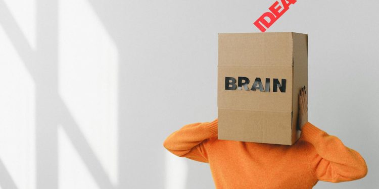Surreal image of a person with a cardboard brain, symbolizing idea and intellect.