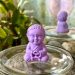 a small buddha statue sitting on top of a jar