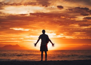 silhouette of man running on beach during sunset