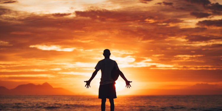 silhouette of man running on beach during sunset