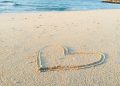 heart drawn on sand during daytime