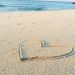 heart drawn on sand during daytime