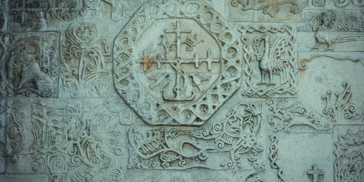 a close up of a stone wall with carvings on it