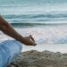 person in blue shorts sitting on beach shore during daytime