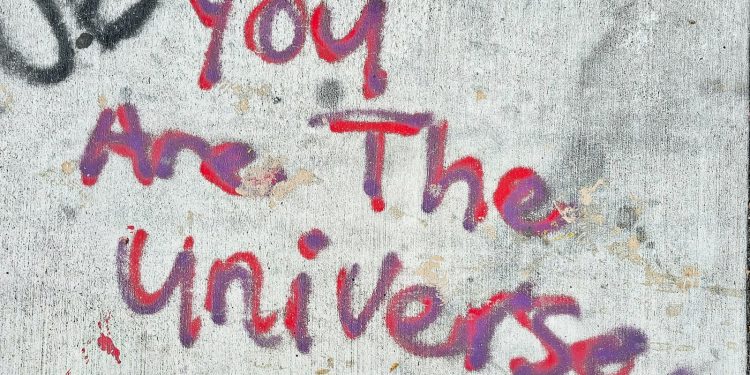 graffiti on a wall that says you are the universe