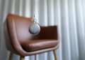 silver round pendant on brown wooden chair