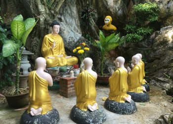 a group of buddha statues sitting next to each other