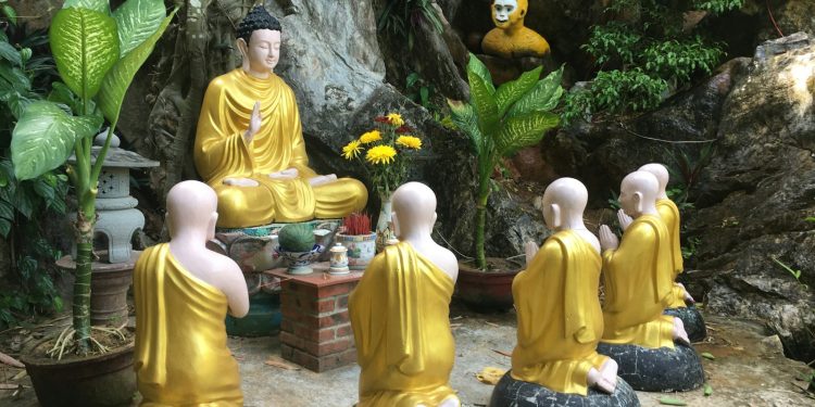 a group of buddha statues sitting next to each other