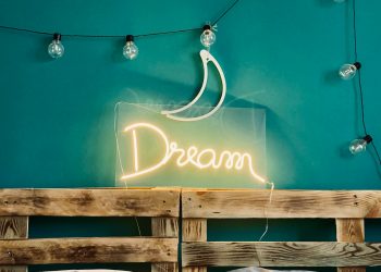 a bed with a neon sign above it