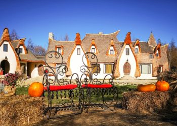 brown wooden bench near brown and white concrete house during daytime