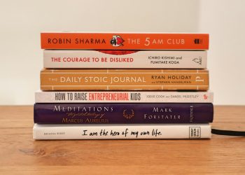 assorted books on brown wooden table