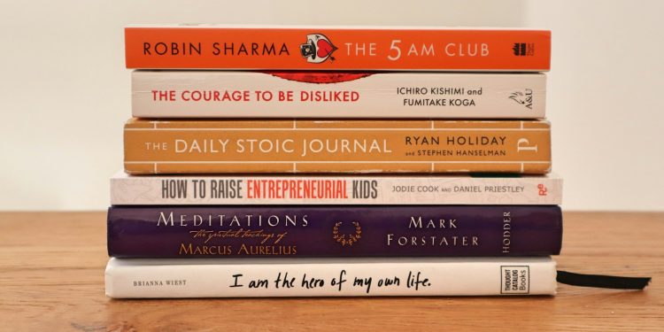 assorted books on brown wooden table