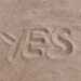 yes text on brown sand