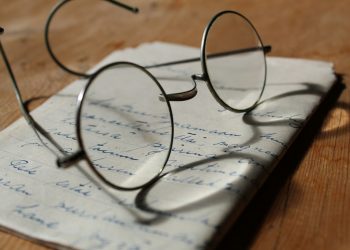 silver-colored framed eyeglasses on white printer paper