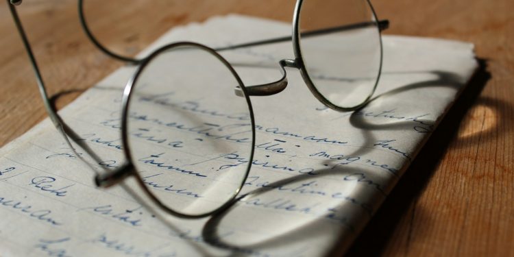 silver-colored framed eyeglasses on white printer paper