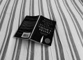 black book on gray and white striped textile