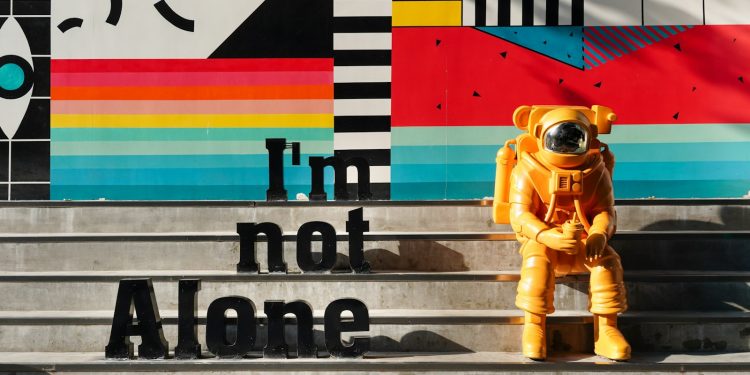 yellow and black robot holding black and white signage