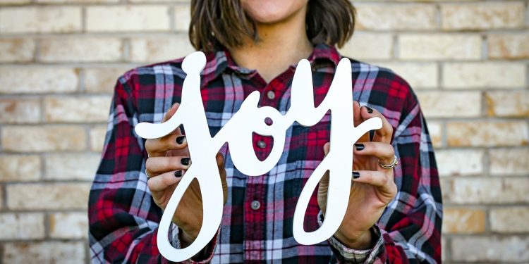 woman holding joy text